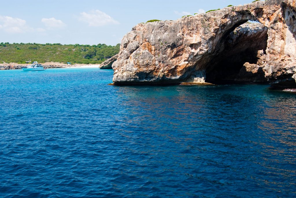 Natural arch and recreational boat at Cala Antena Majorca island Spain shutterstock 54519319 2 1024x685 1 Die schönsten Strände zum Tauchen auf Mallorca