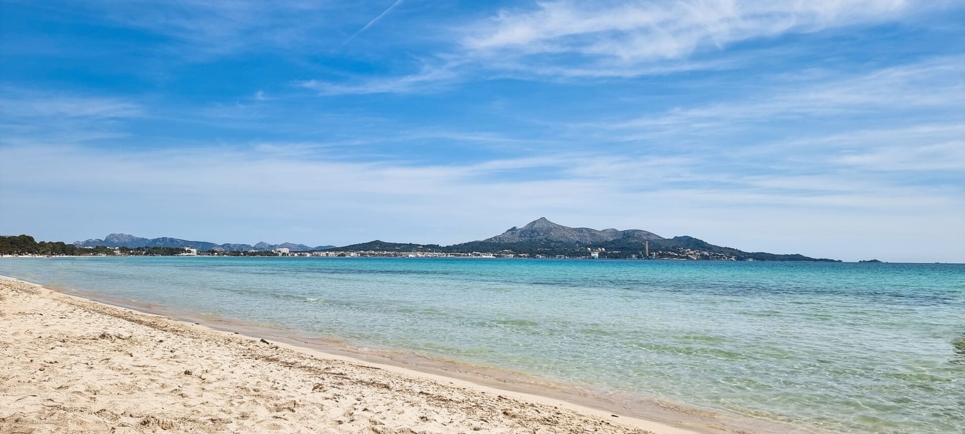 sandy beach and crystal clear blue waters lapping 2023 11 27 05 08 09 utc Discovering the coast of northern Mallorca by Car: From Alcúdia to Formentor