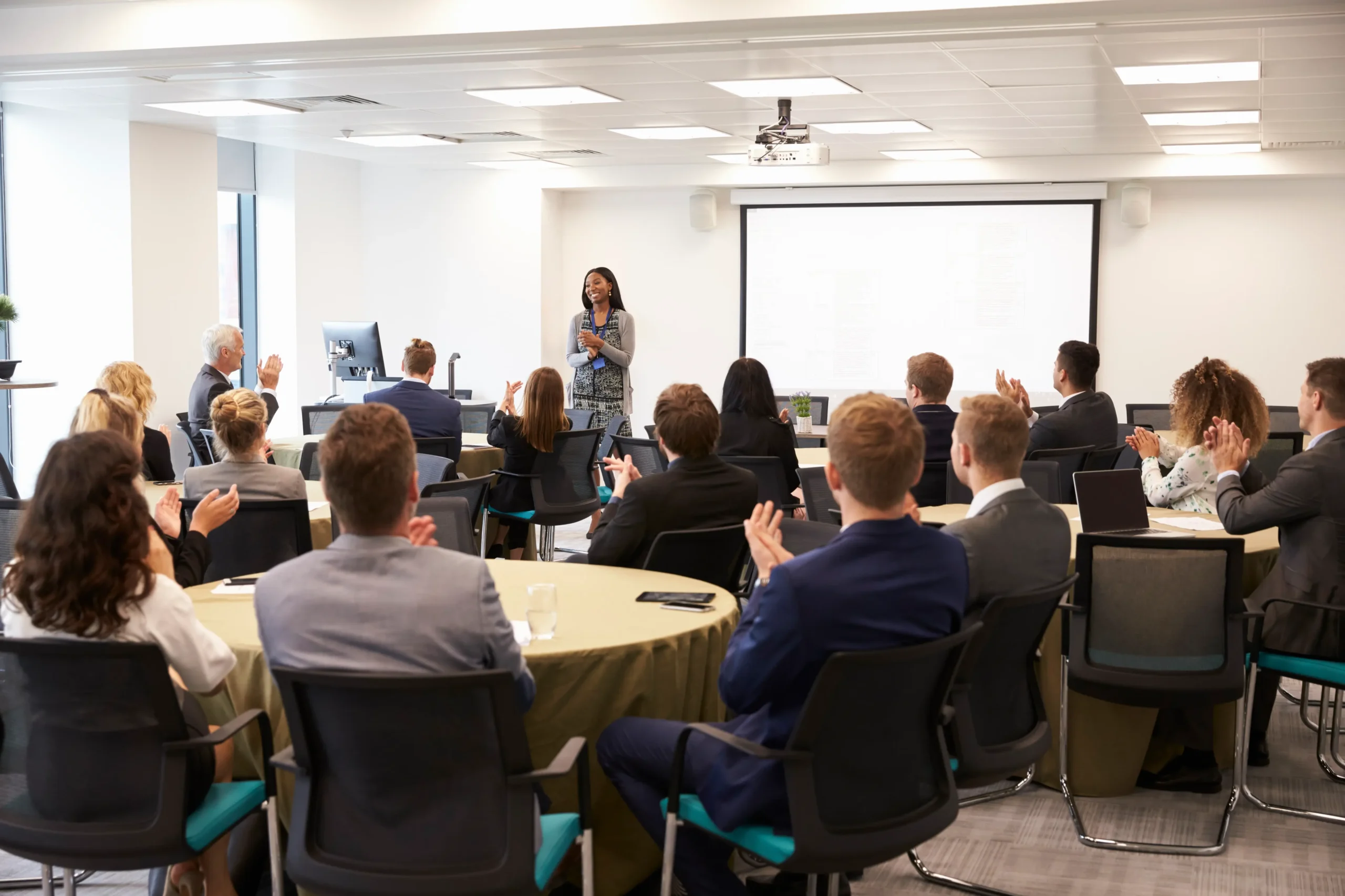 delegates-applauding-businesswoman-making-presenta-2024-10-19-04-30-00-utc